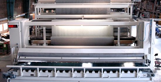 Surface winder for in-line slitting and winding of nonwoven